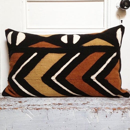 Brown, black, and white mudcloth pillows with geometric designs styled on Scandinavian bench. Modern pillows made in USA, designed in Mali