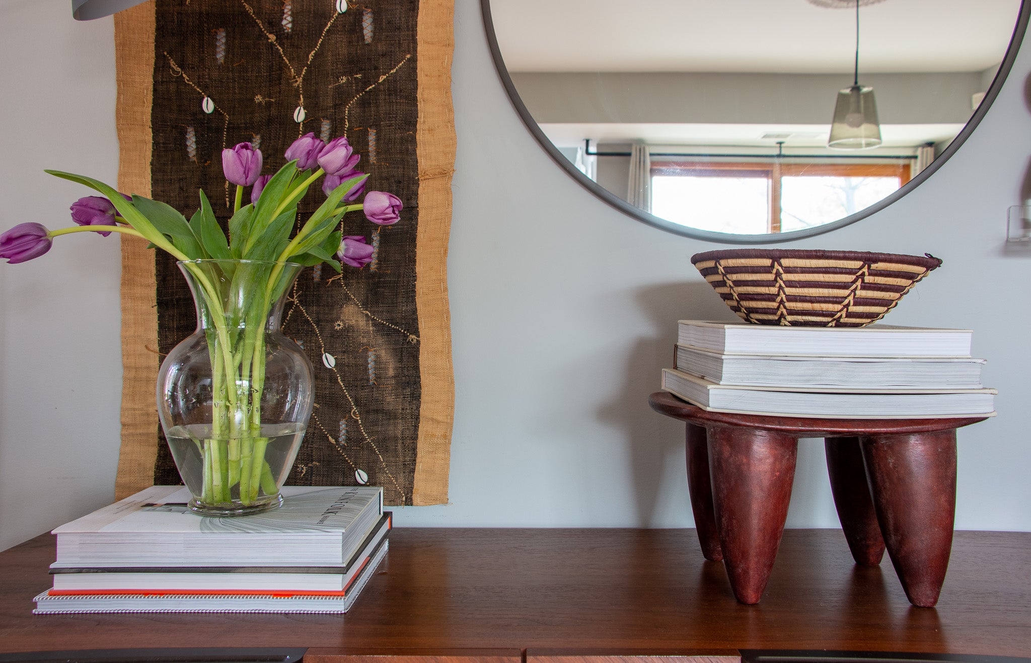 Minimalist console styling and decor featuring a Senufo stool.