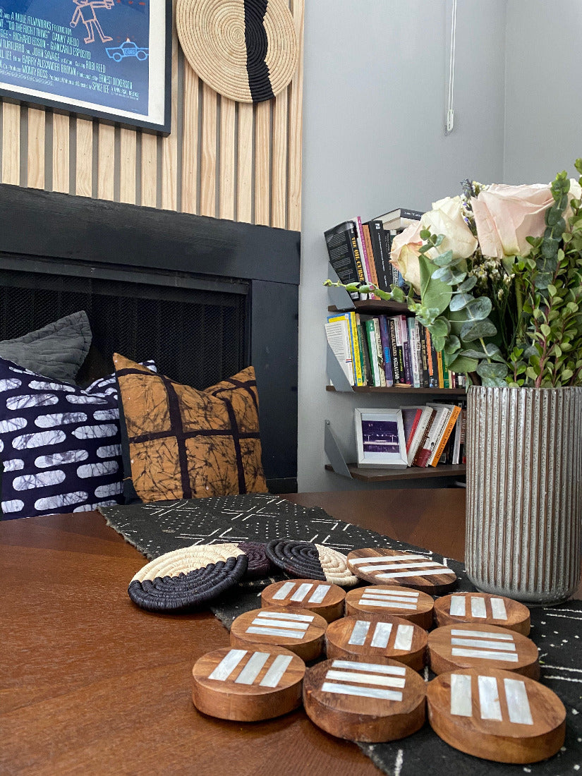 Pot holder. Fair Trade home goods and table top trivet, made in Uganda from acacia wood and cowhorn. Perfect for housewarmings and wedding gifts. Seen here with mudcloth table runner and batik pillows.