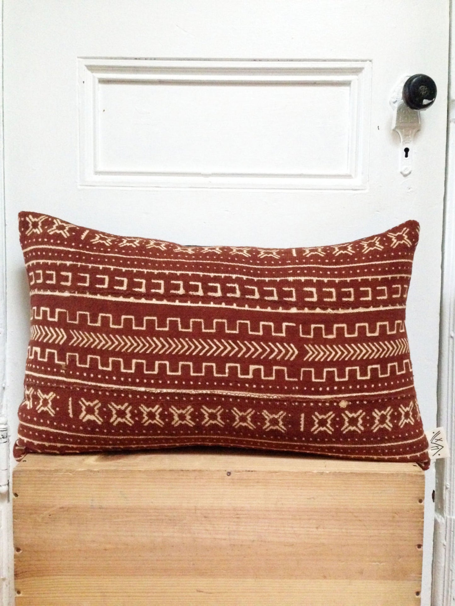 Sienna brown mudcloth pillows with minimalist geometric designs. Modern pillows made in USA, designed in Mali. Seen here with African art.