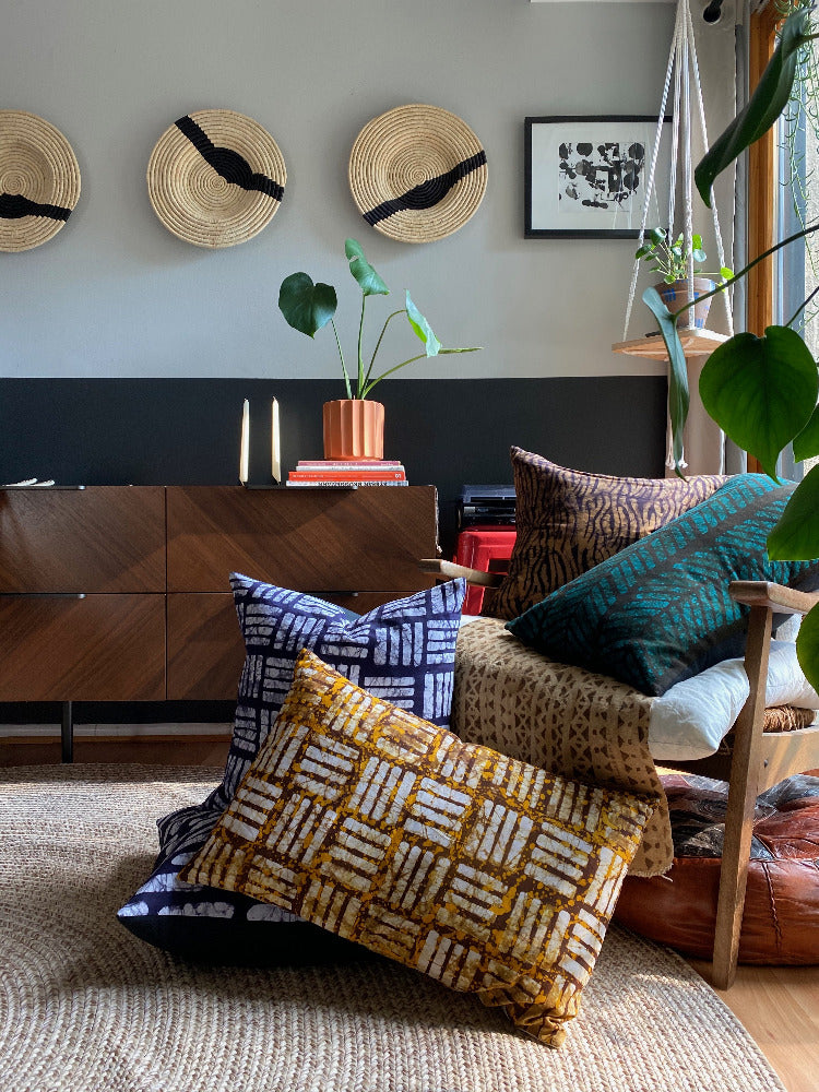 Batik and mudcloth textile home goods in modern Boho home, pillows made in Tanzania. African art.